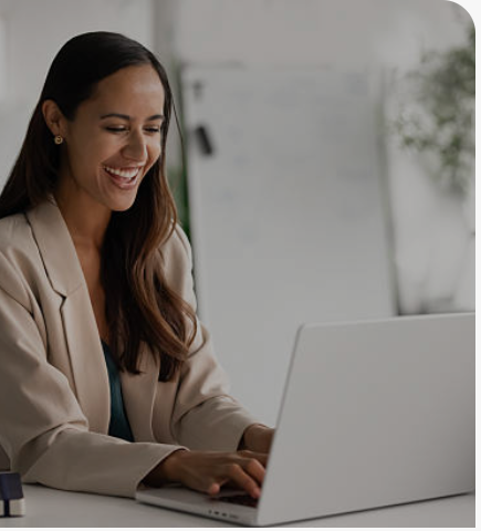 A business owner smiling while reviewing results on a laptop